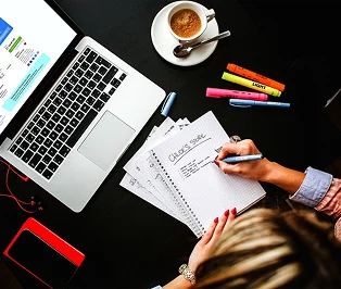Marketing planning desk with laptop and notebook